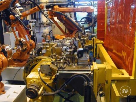Isla de soldadura robotizada de Industrias Ríos con robots articulados naranjas junto a un útil de sujeción amarillo